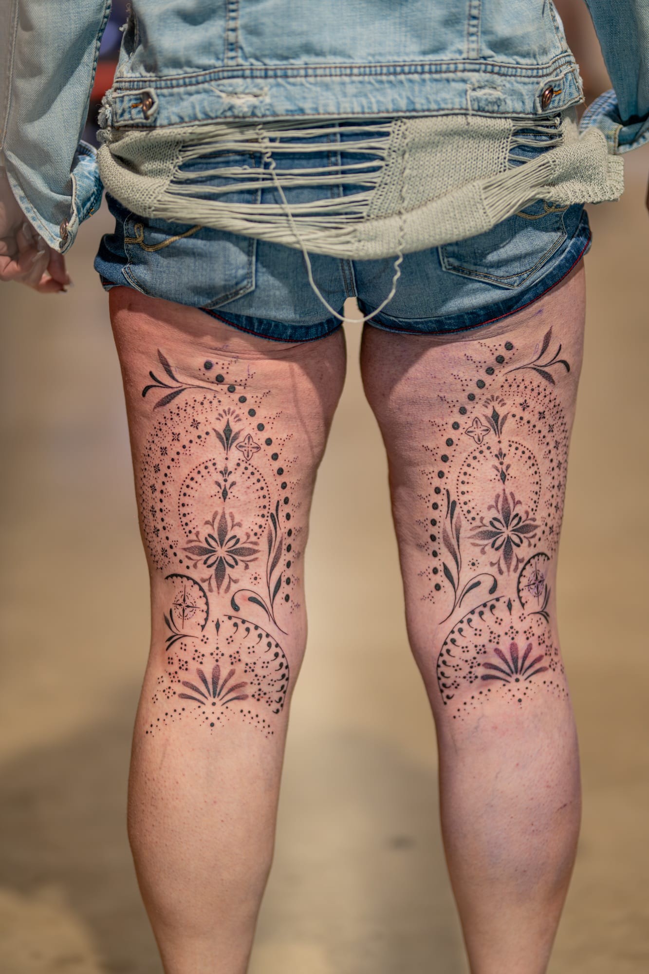 Composition ornementale en fine line réalisée en miroir sur les deux cuisses, mêlant dotwork, motifs floraux et détails graphiques dans une parfaite symétrie.