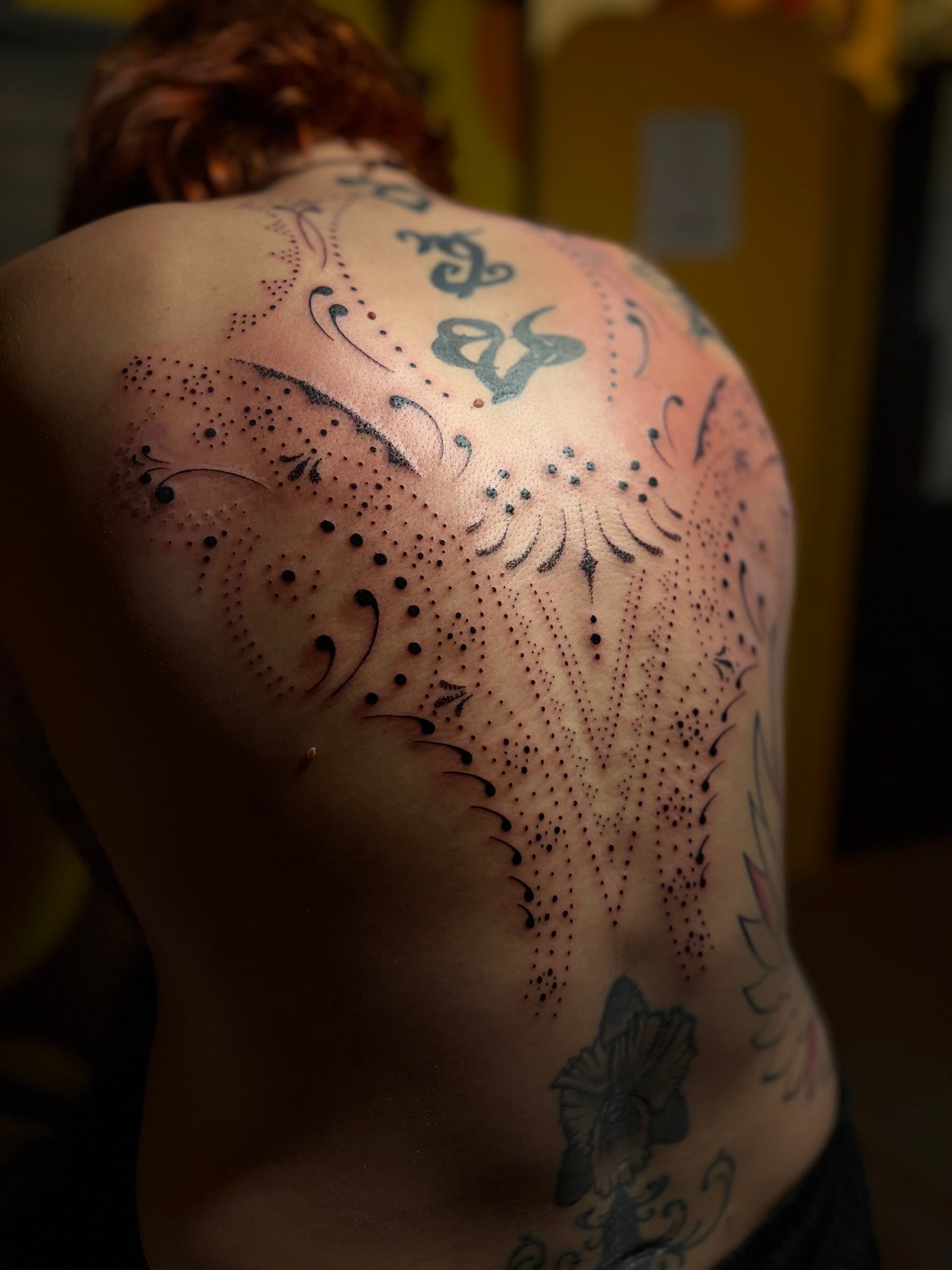 Projet ornemental en fine line mêlant dotwork, courbes délicates et motifs graphiques dans une composition parfaitement symétrique.