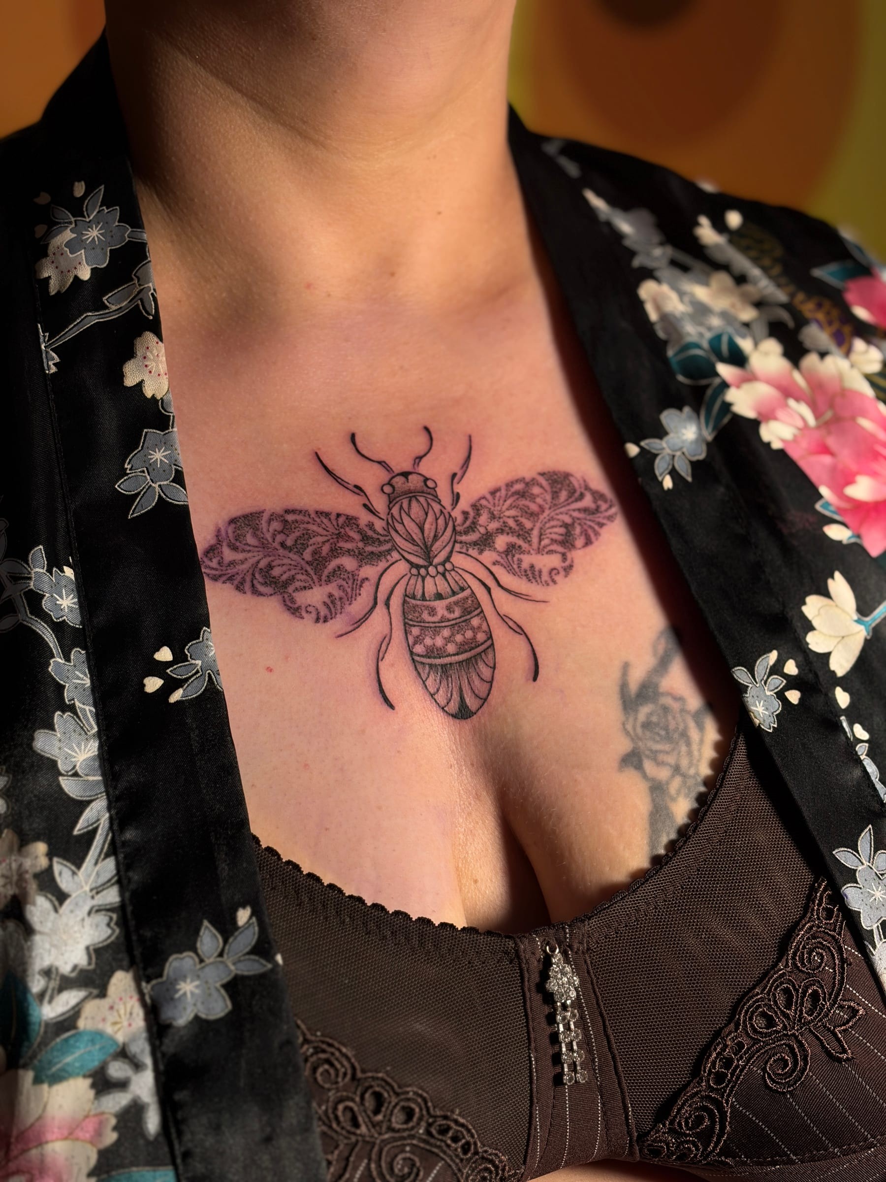 Tatouage en fine line représentant une abeille ornée de motifs délicats, où le dotwork et les lignes épurées mettent en valeur chaque détail.