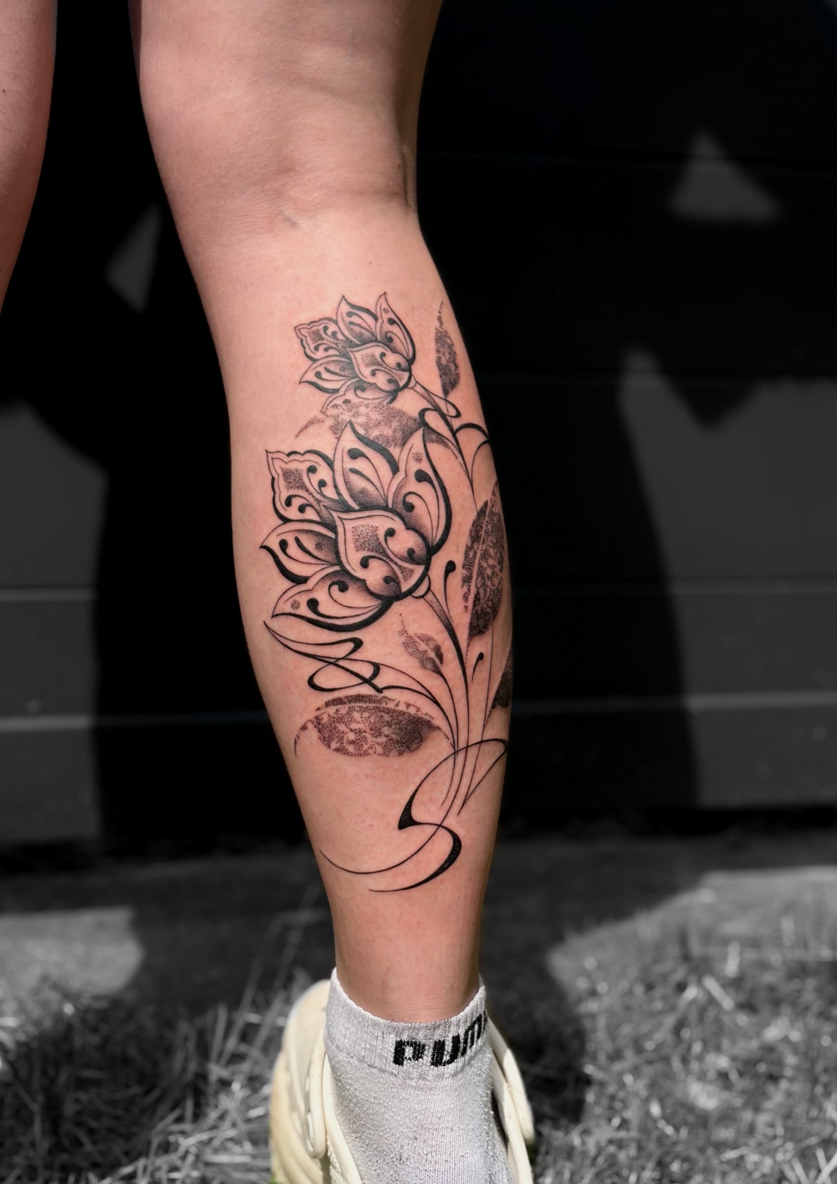Projet floral en fine line inspiré des motifs ornementaux, mêlant courbes élégantes, dotwork délicat et aplats profonds. Une composition fluide qui épouse naturellement la ligne du mollet tout en jouant sur les contrastes et la finesse des détails.